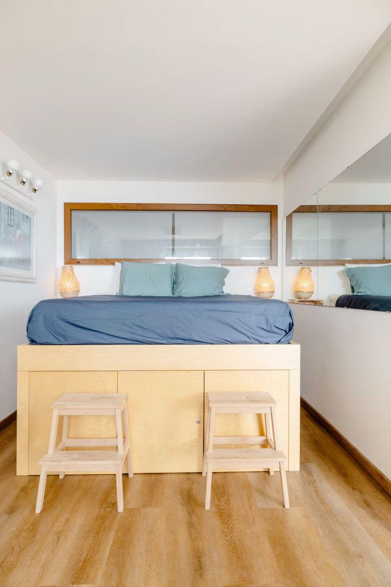 Quarto com cama em estrado de madeira