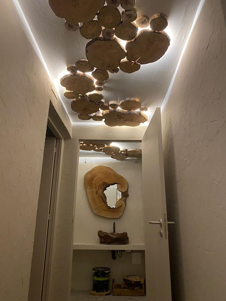Corredor com teto em rodelas de madeira e luz indireta